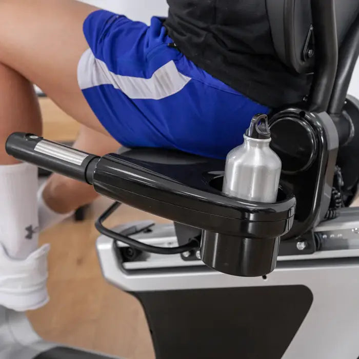 a person sitting on the rbx-100 bike from the seat and showing you can fit a drink bottle